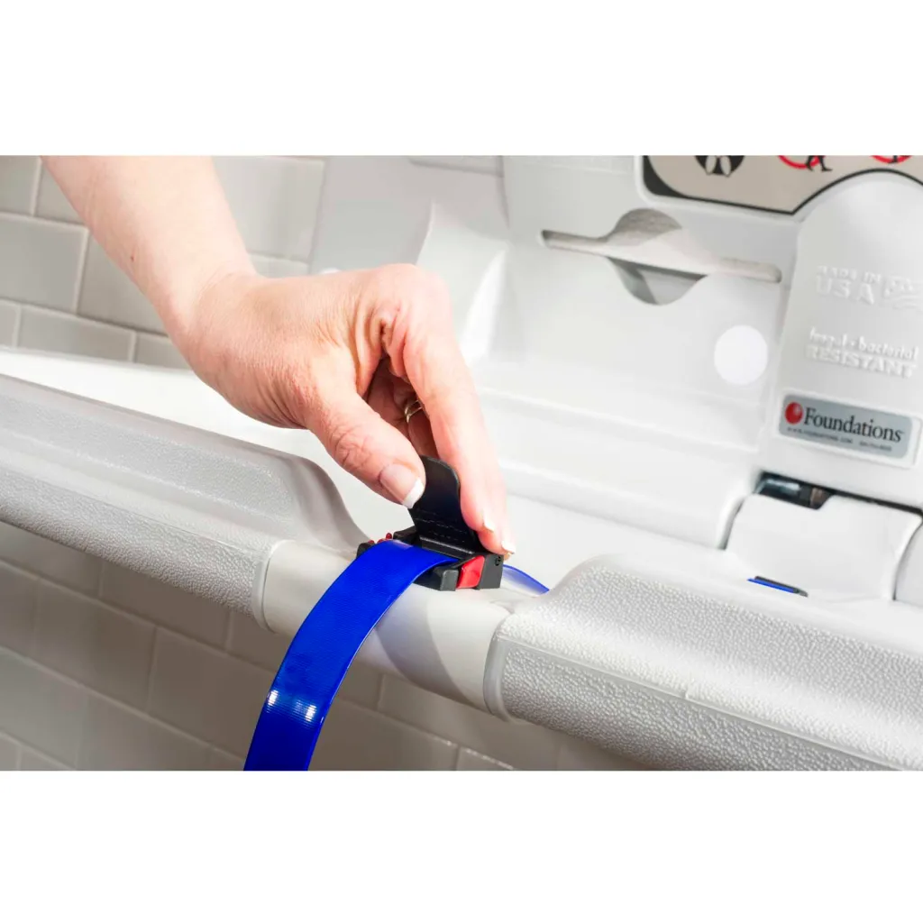 Hand buckling blue strap on white baby gate