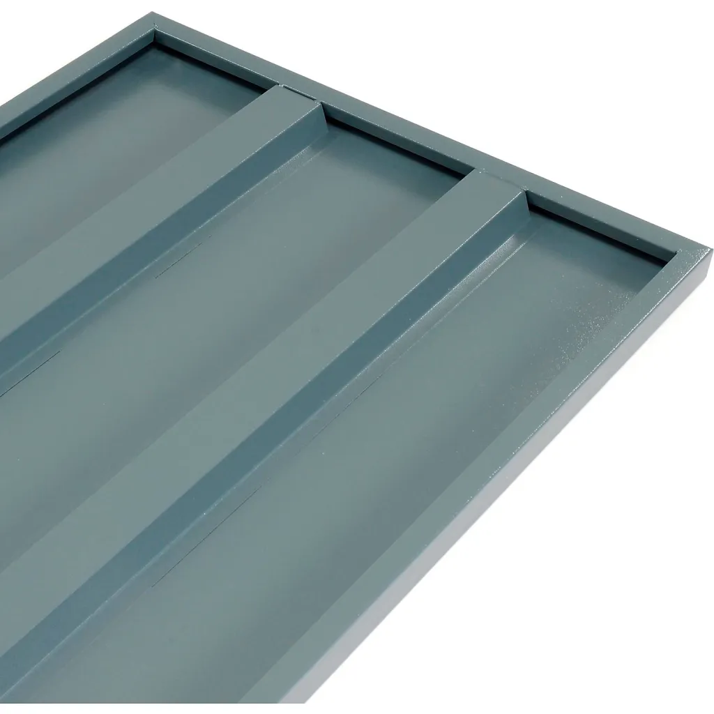 A close-up of a gray metal drawer's corner, showing its textured surface and compartmentalized interior.