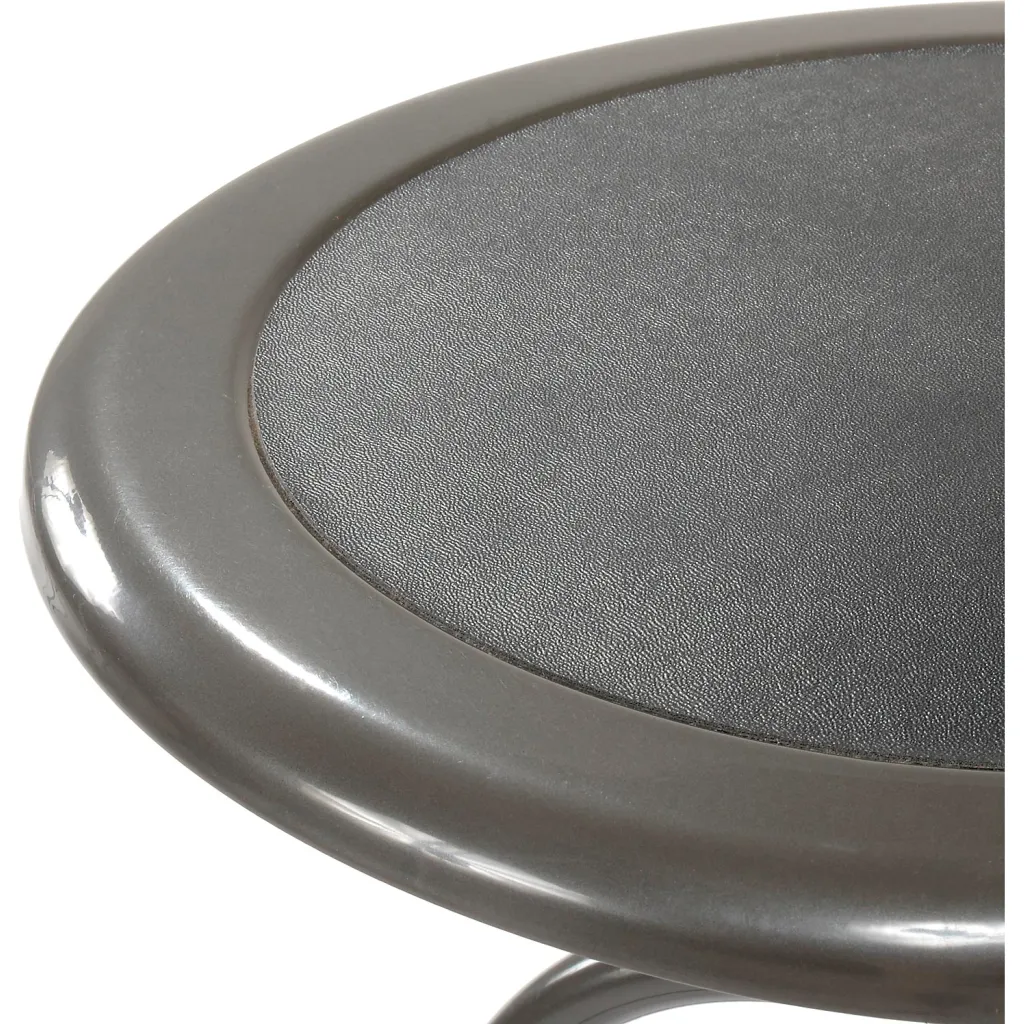 A close-up of the round seat of a gray metal stool.