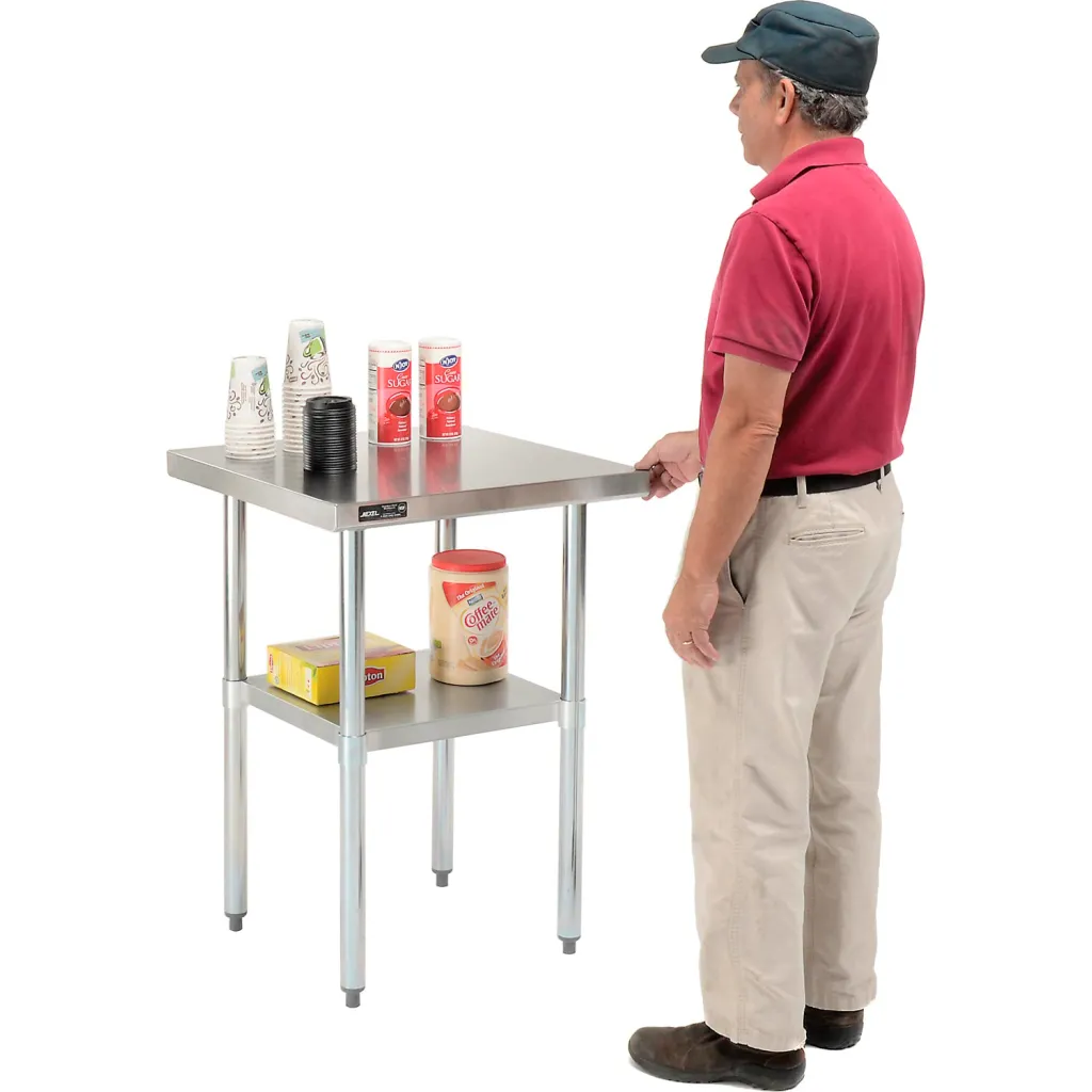 Man standing next to stainless steel workbench