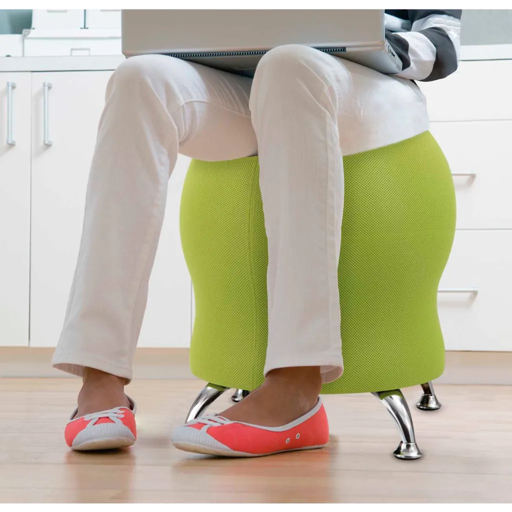 A green, egg-shaped chair with a silver base, being used by a person in casual attire.