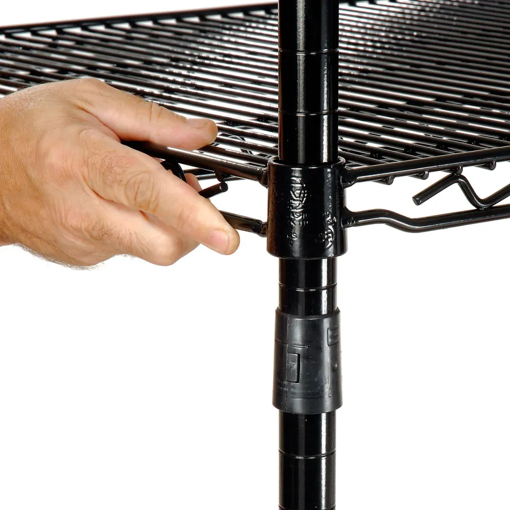 A hand adjusting a black metal shelving unit's shelf.