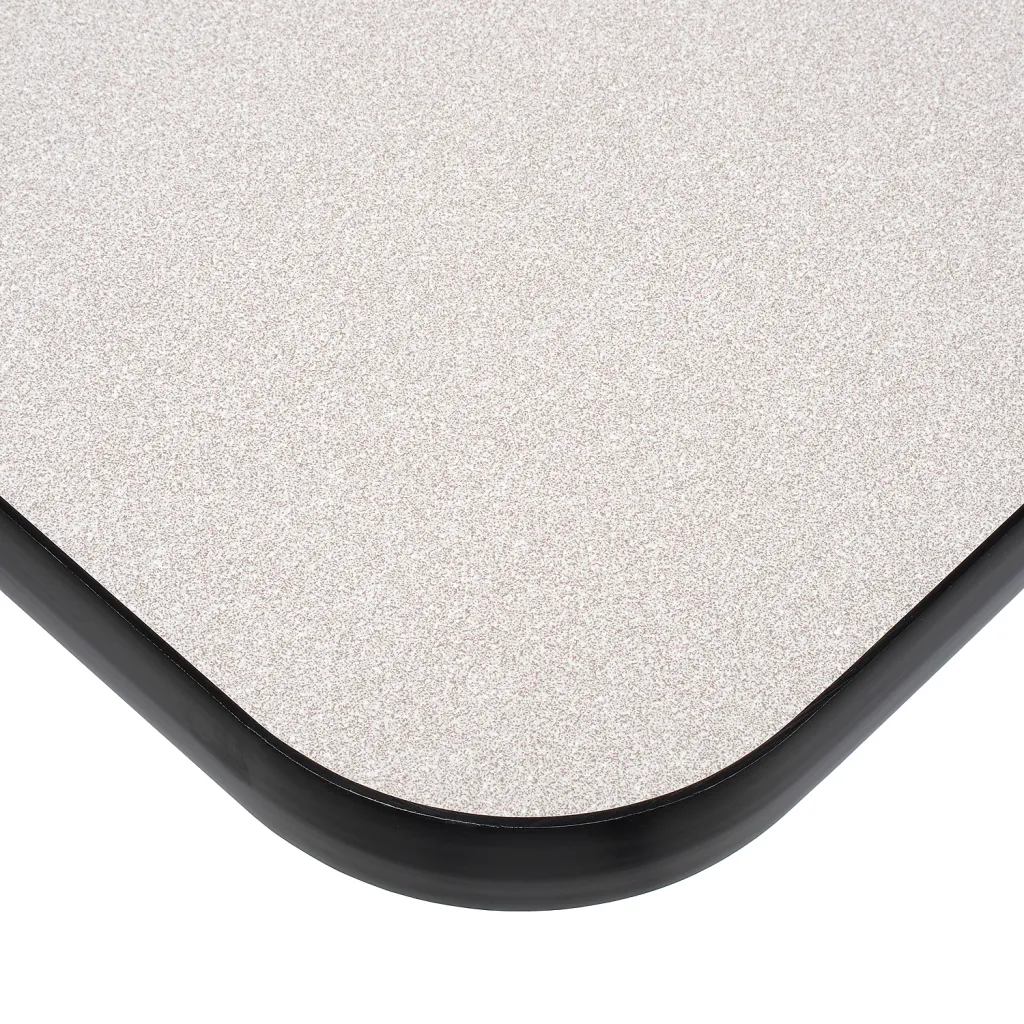 Close-up of a table's corner, showing a gray surface with a black edge