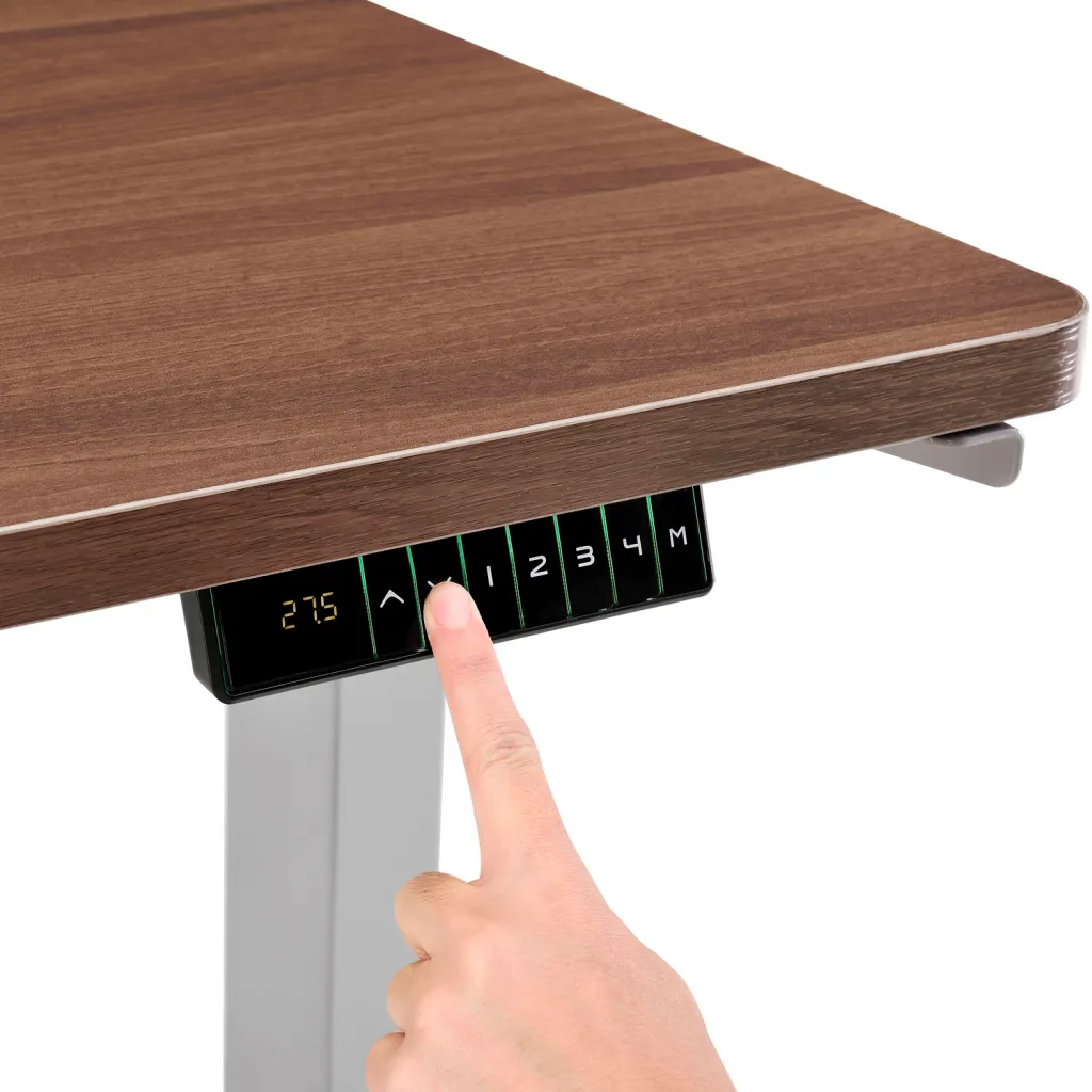 Close-up of desk control panel with hand pressing button