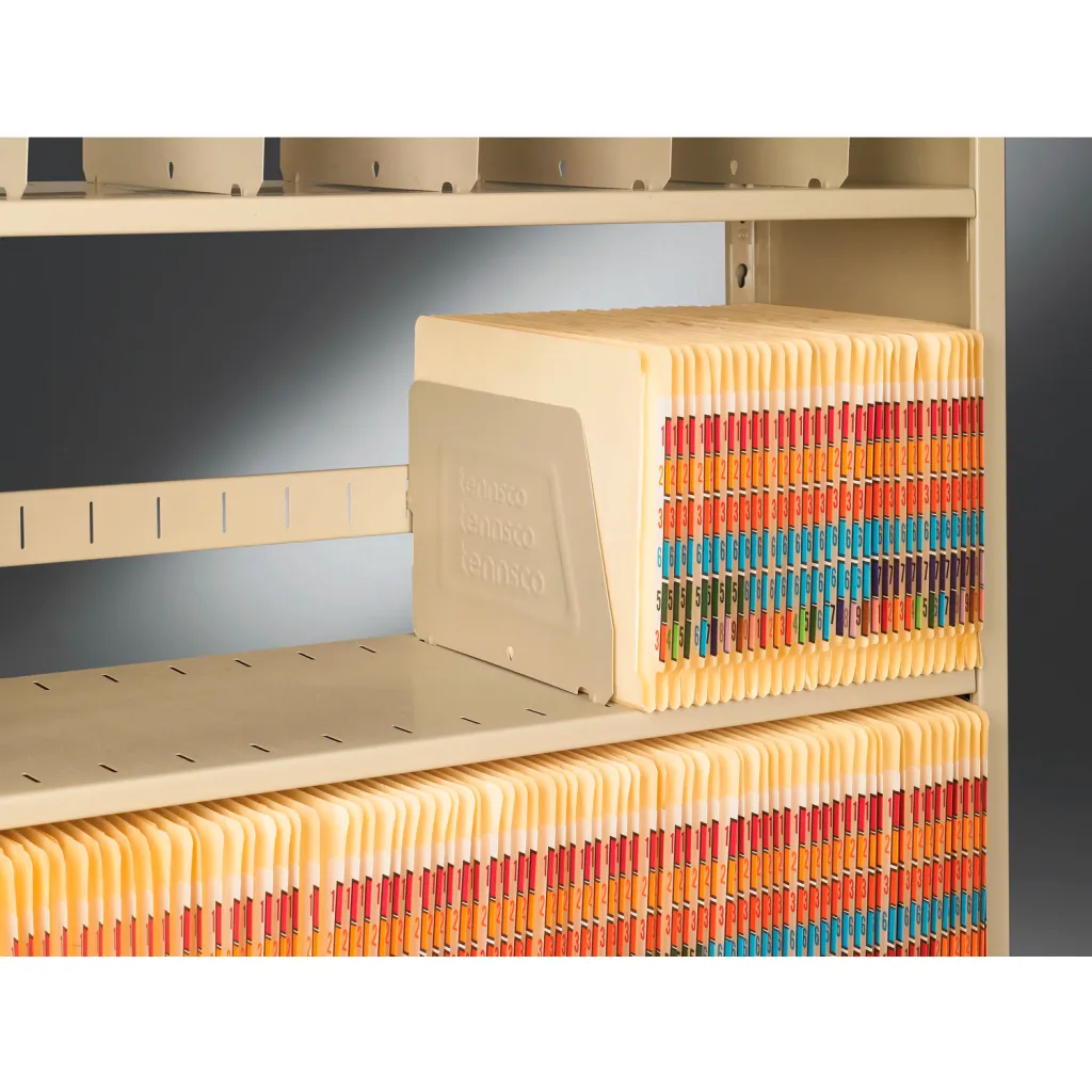 A close-up of a beige file shelving unit with hanging files and file dividers.
