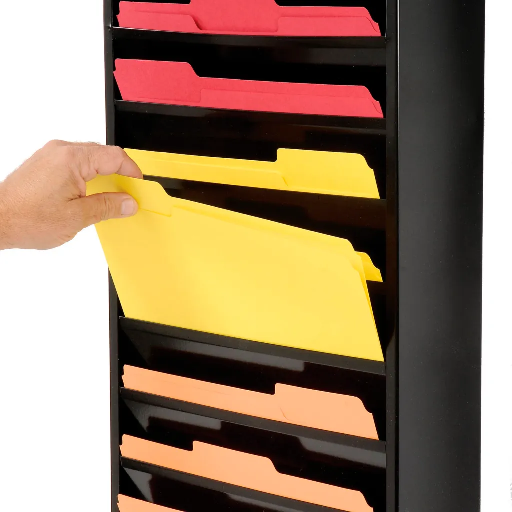 A hand holding a yellow file folder from a black magazine rack.