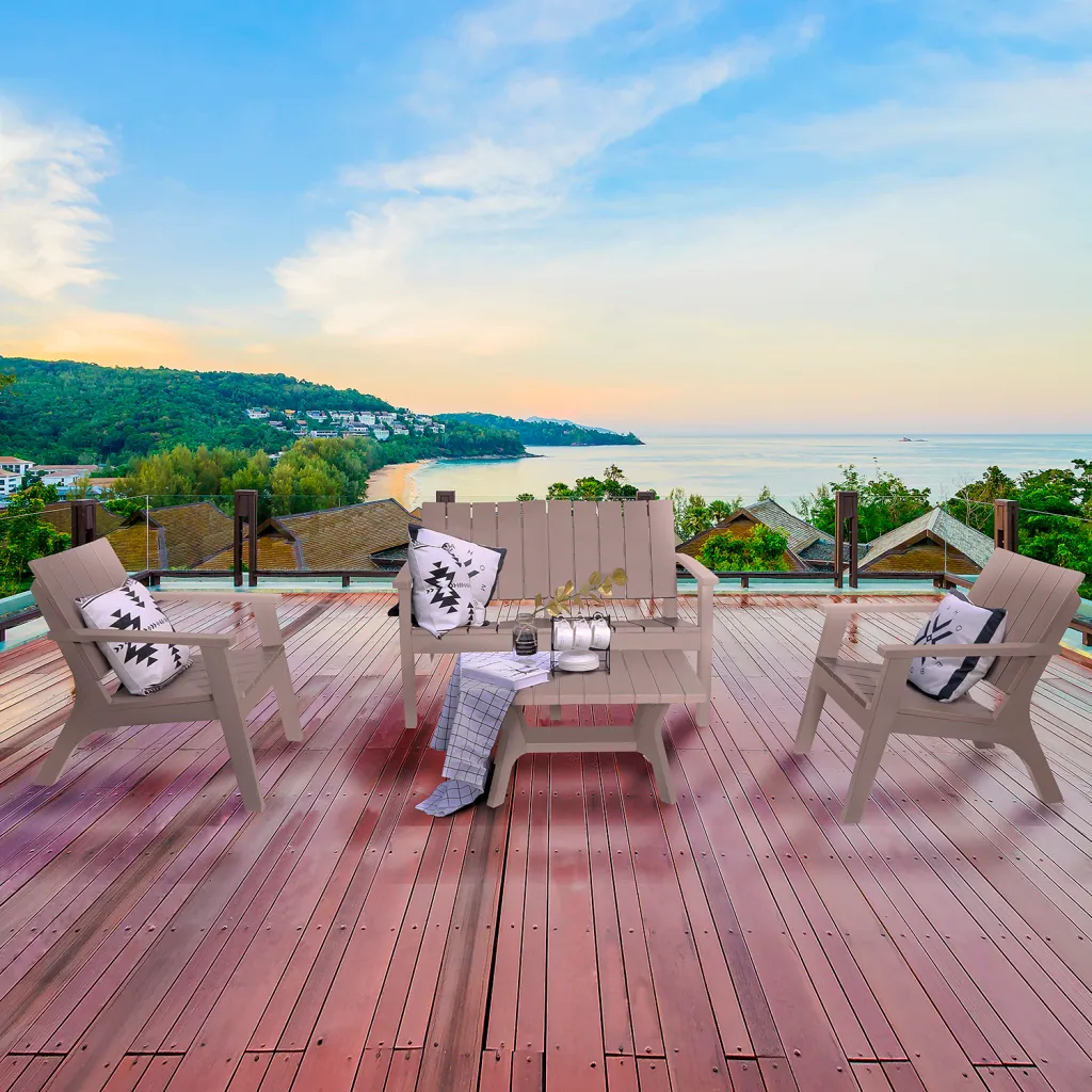 Gray outdoor furniture set with two chairs, a bench, and a coffee table on a deck overlooking the ocean