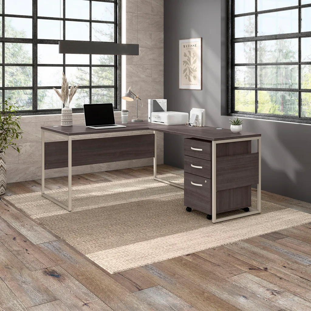L-shaped brown desk with metal legs and drawers in office setting