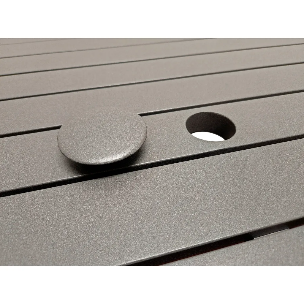 Close-up of gray table top with slatted design, circular hole, and removable plug