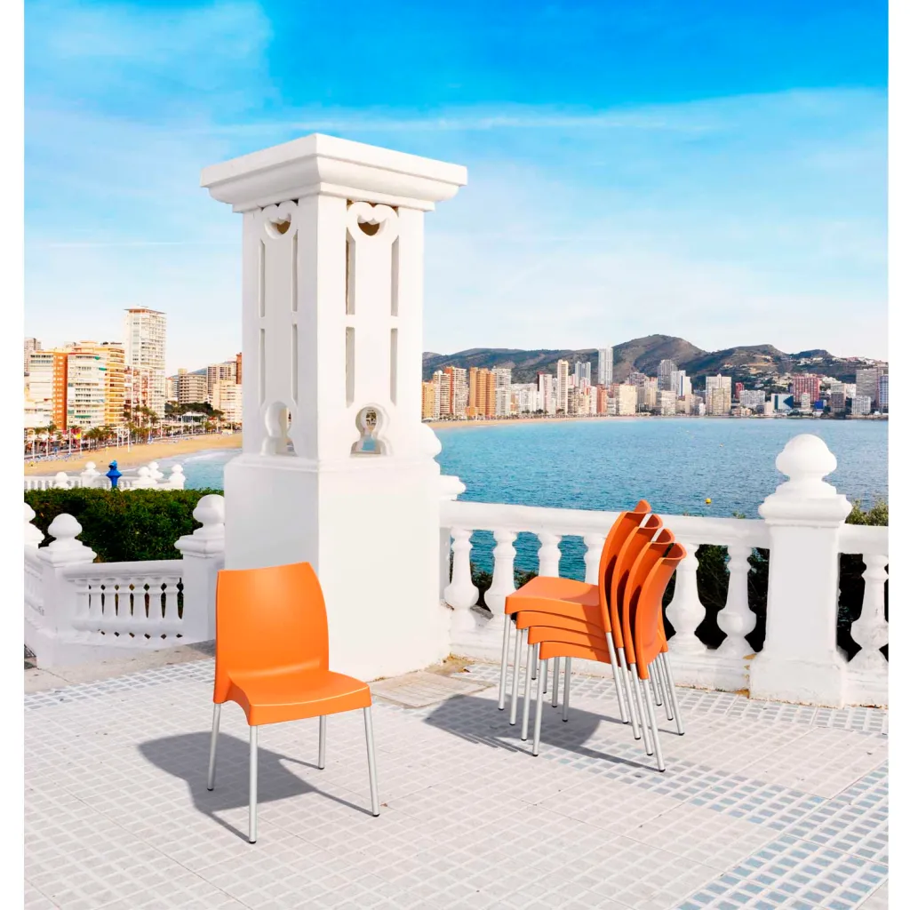 Multiple orange chairs on a balcony overlooking the water