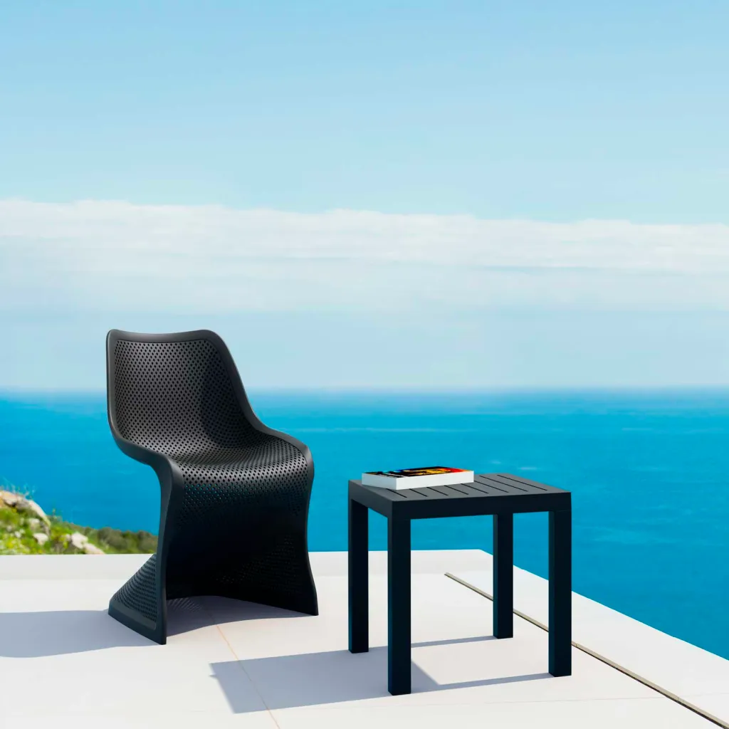 Black outdoor chair and side table by the ocean