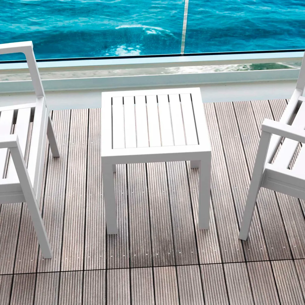 White outdoor table and chairs on deck overlooking water
