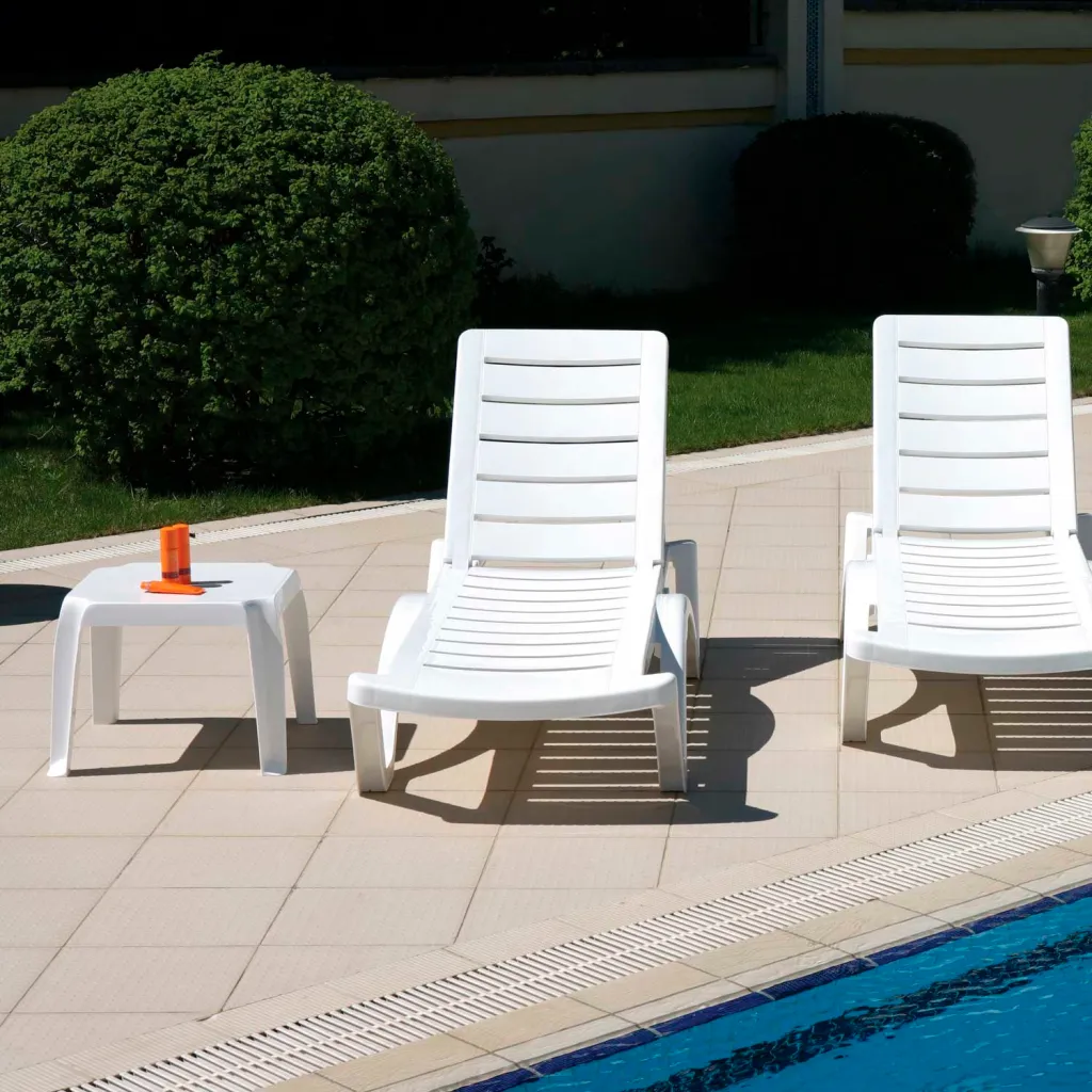 White plastic table and chairs by a pool