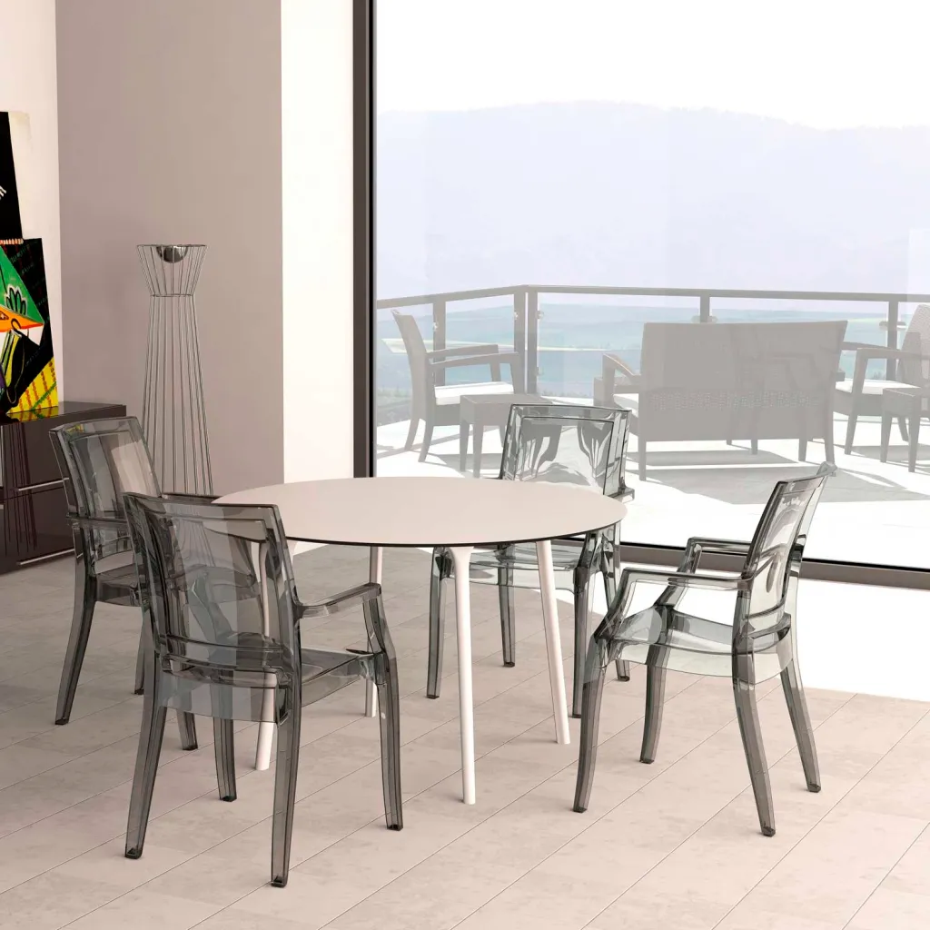 White round table with four white legs and clear chairs in a room