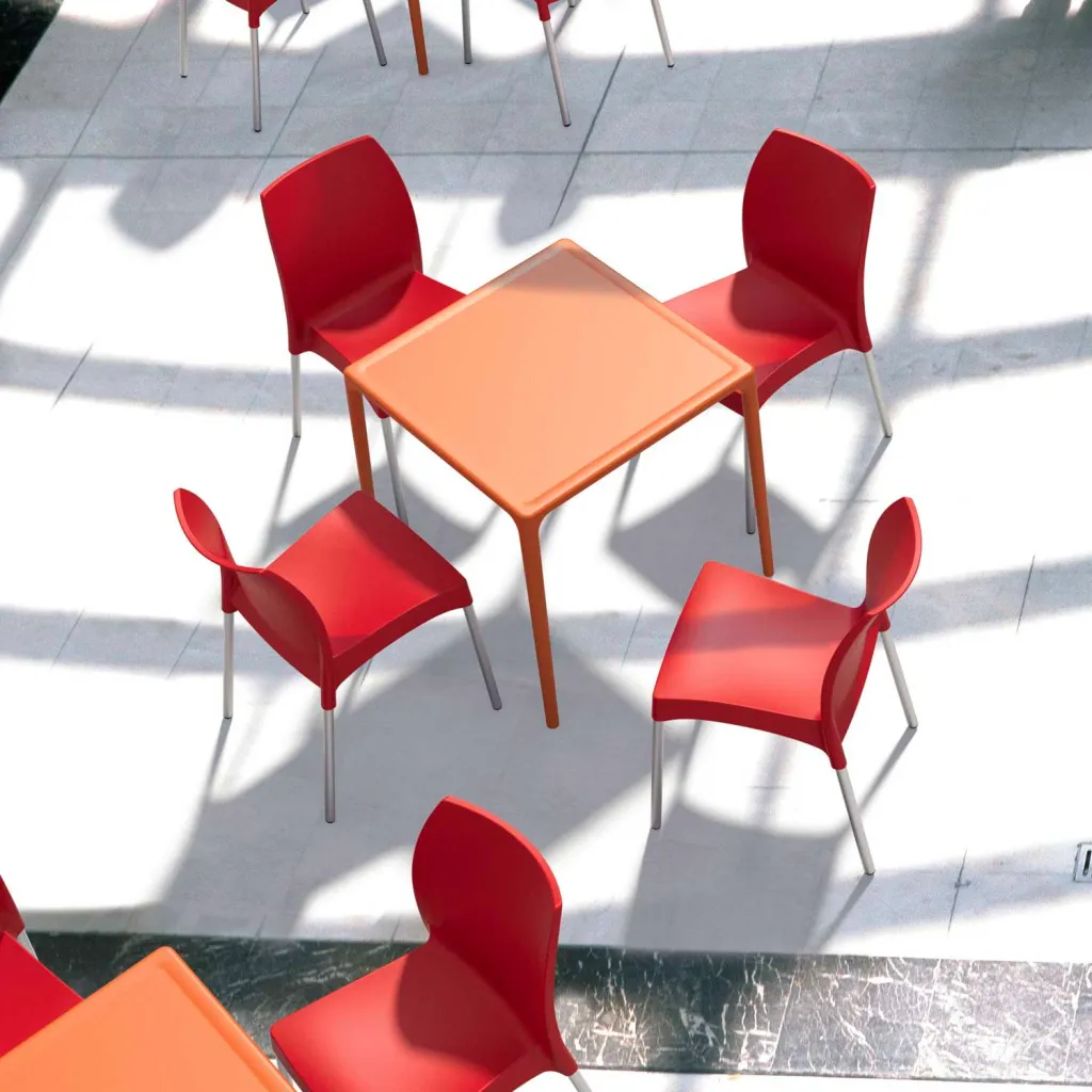 Orange table with four red chairs on tiled floor