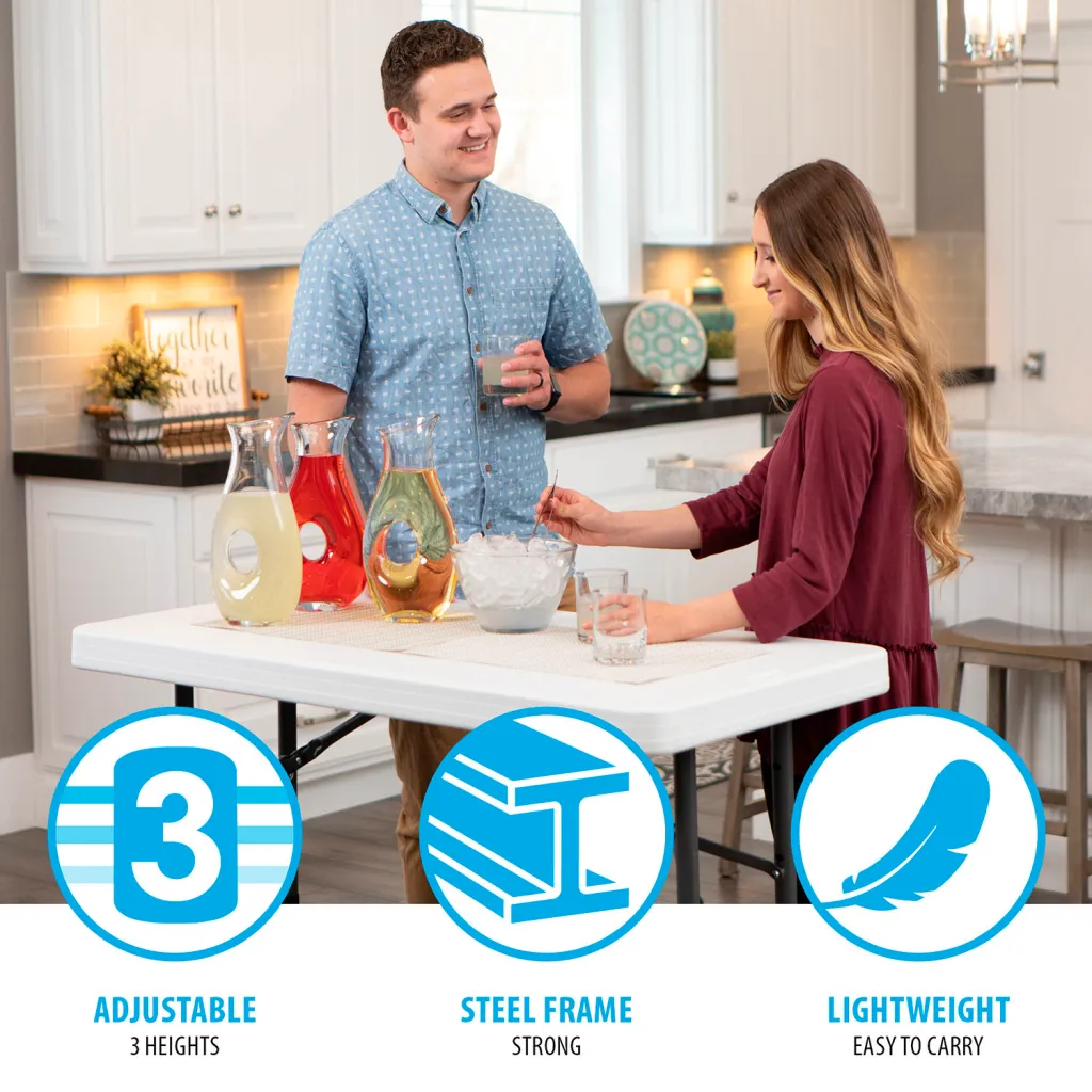 A white folding table with black metal legs and a man and woman standing around it.