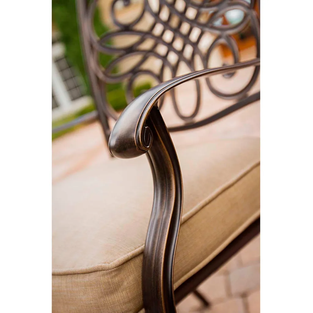 Close-up of bronze-finished metal outdoor chair arm.
