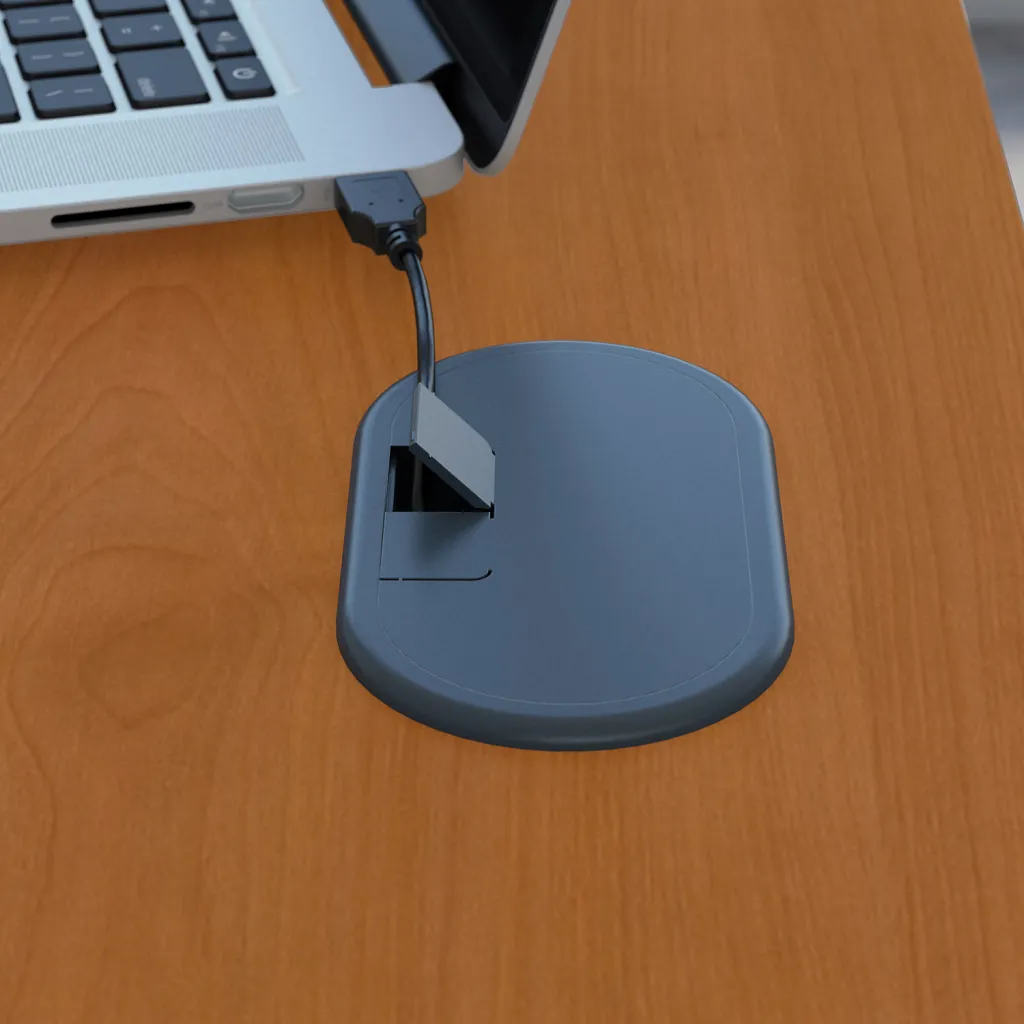 A close-up of a desk with a laptop and a cable management system
